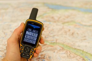 Hand,Held,Outdoor,Gps,And,A,Hiking,Map.